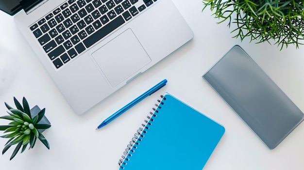 Photo open laptop with blue notebook and metallic pens on a white surface