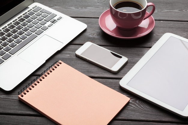 Open laptop with digital tablet and white smartphone close up top view