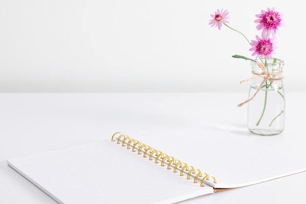 Open notebook and flower on table