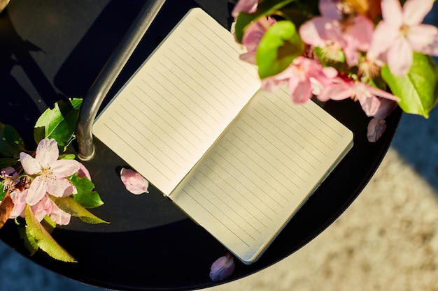 Open notebook and flowers and on the small black table on terrace