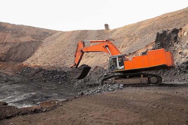 Open pit Manganese Mining - Excavator digging out ore rich rock and loading it onto rock dump trucks for processing