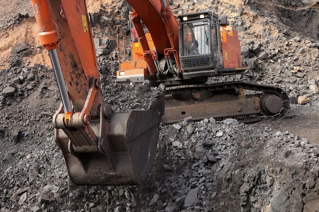 Open pit Manganese Mining - Excavator digging out ore rich rock and loading it onto rock dump trucks for processing