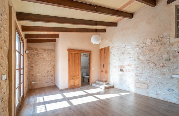 Open plan empty master bedroom with parquet floors, wooden beams, balcony and air conditioning