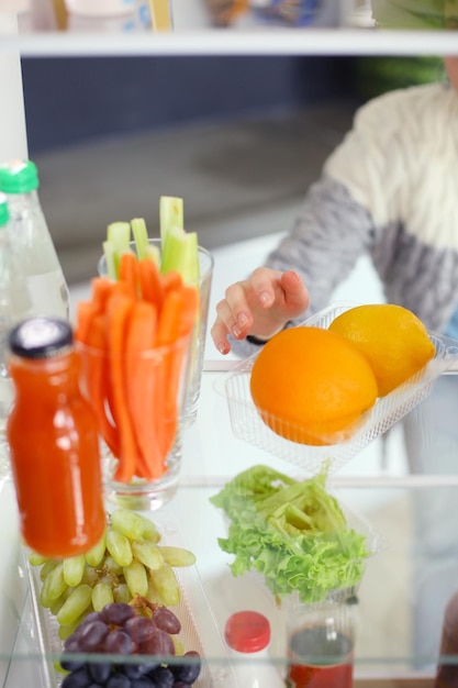 Open refrigerator with fresh fruits and vegetable Open refrigerator