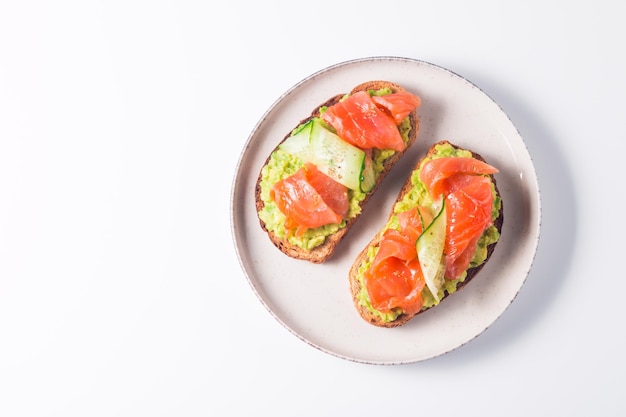 Open sandwich with smoked and salted salmon for healthy breakfast. Trout and avocado on bruschetta t