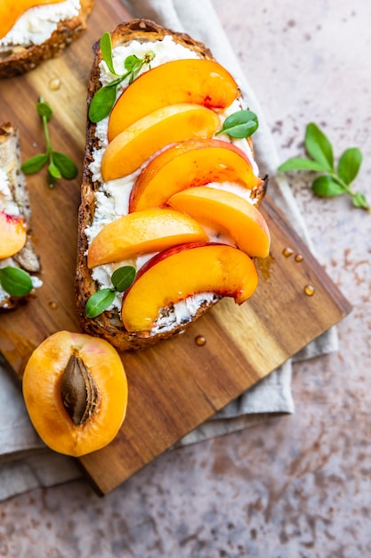 Open sandwiches with tartine bread and cream cheese nectarine and apricot drizzled with honey