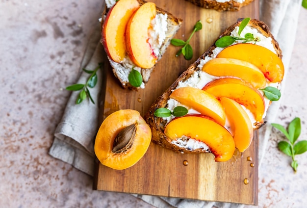 Open sandwiches with tartine bread and cream cheese nectarine and apricot with honey