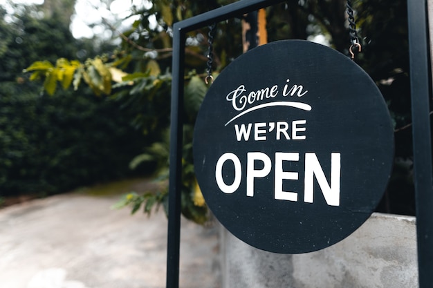 Open sign broad hanging on wood door front of cafe.