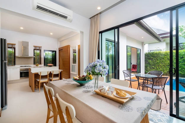 Open space dining with pool view next to livign room