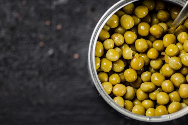 An open tin can with green peas