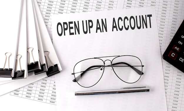 OPEN UP AN ACCOUNT text on paper with chart and office tools business concept