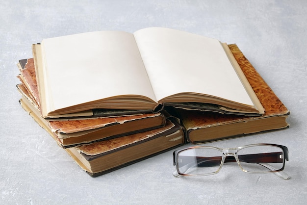 Open vintage book notepad with blank pages and glasses