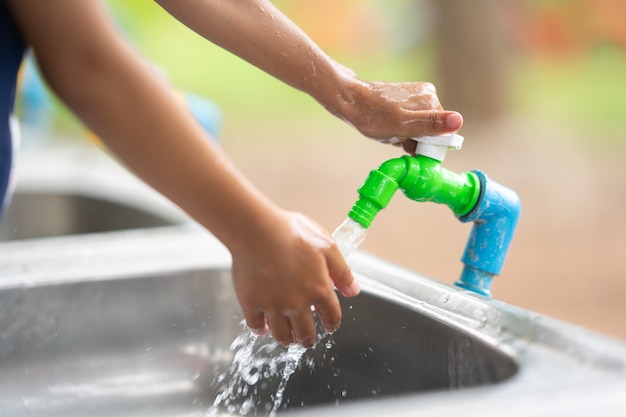 Open water tap cleaning hand on sink