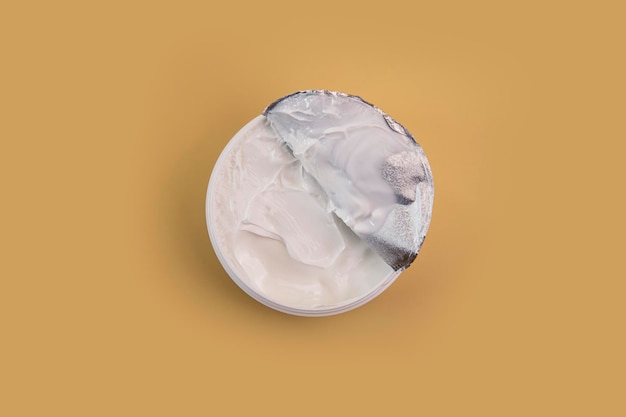 Opened cream as a sample of a cosmetic product on a beige background Top view flat lay