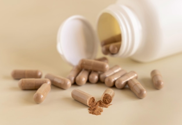 Opened Medical capsules on light beige close up Taking dietary supplements