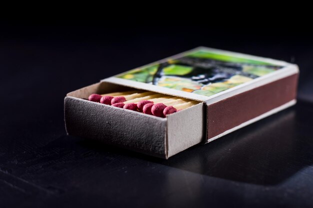 Opened old box of matches isolated on dark background top view