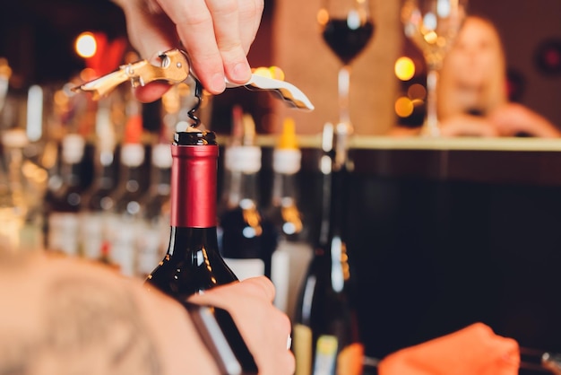 Opening a bottle of wine corkscrew closeup