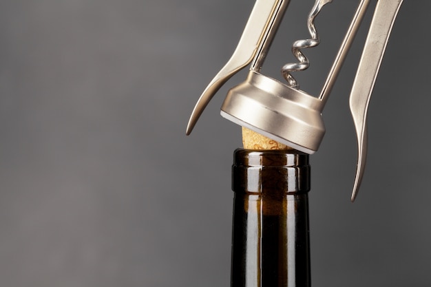 Opening wine bottle with a corkscrew close up