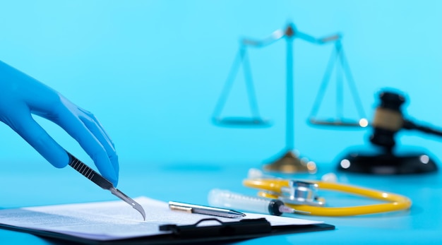 Operation being performed by a doctor while a Patient relative signs a document agreement with consent scalpel blade used as a pen for lawyer legal documents insurance and protection copy space