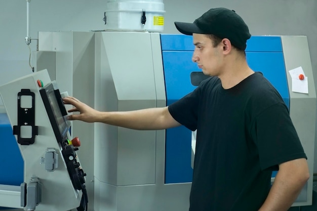 An operator of cnc is at work near the panel of management a machinetool