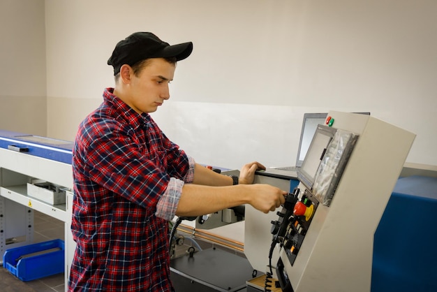 An operator of cnc is at work near the panel of management a machinetoolxA