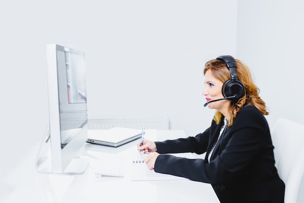 Operator woman agent with headsets working in a call centre.