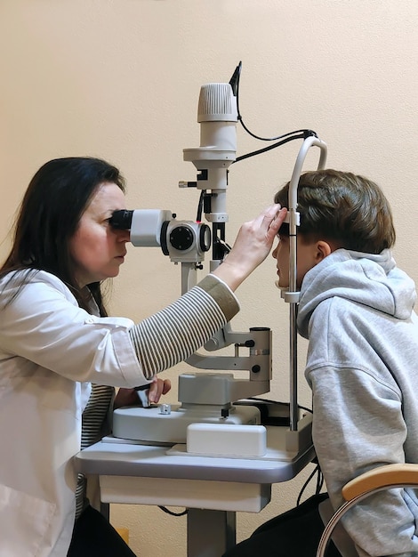 An ophthalmologist examines a teenage boy's vision using a special device