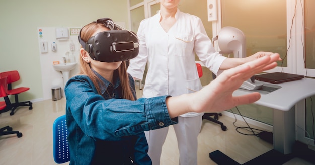 Ophthalmology doctor checks the girl's vision with the help of virtual reality goggles.