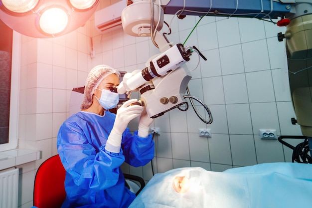 Ophthalmology operation Surgeon's hands in gloves performing laser eye vision correction with microscope Modern clinic concept