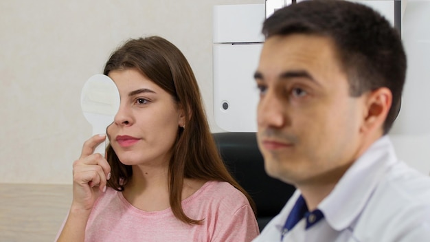 Ophthalmology treatment young woman checking her visual acuity closing her eye with an eye shield