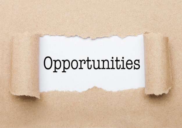 Opportunities concept text appearing behind torn brown paper envelope