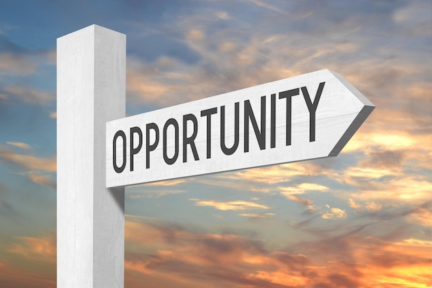 Opportunity white wooden signpost with one arrow and sunset sky in background