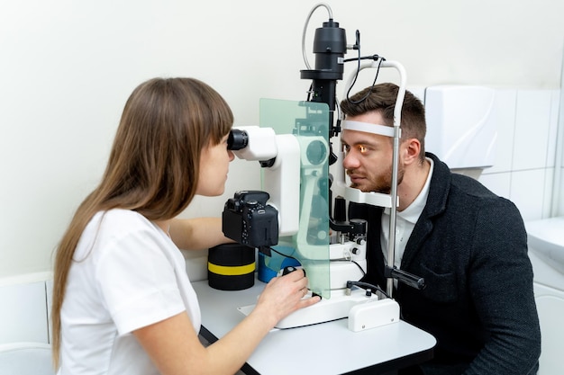 Optician specialist eyesight testing Young optometrist examining patients eyes