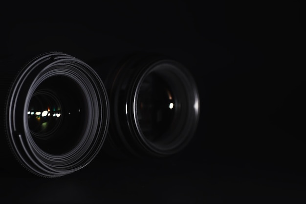 Photo optics to the camera on the operator's desk flare in the glass of a photo lens black background with the technique of the photographer