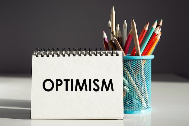 Photo optimism - inscription on a notebook with colored pencils.