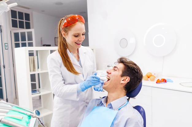 Optimist dentist and patient during teeth examination