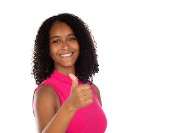 Optimistic young beautiful African American woman wearing pink tshirt against white wall showing thumbs up with positive emotions