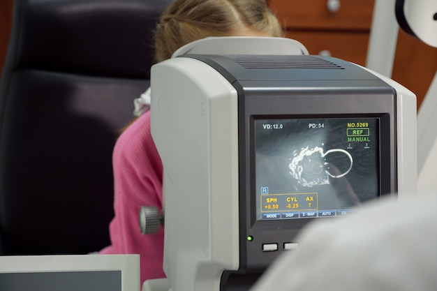 Optometrist examines the sight the little girl.