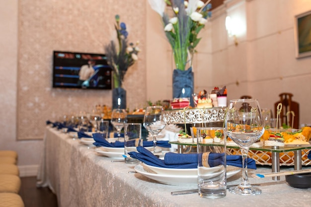 Opulent buffet with snacks sandwiches fruits sweets on decorated table with blue accents