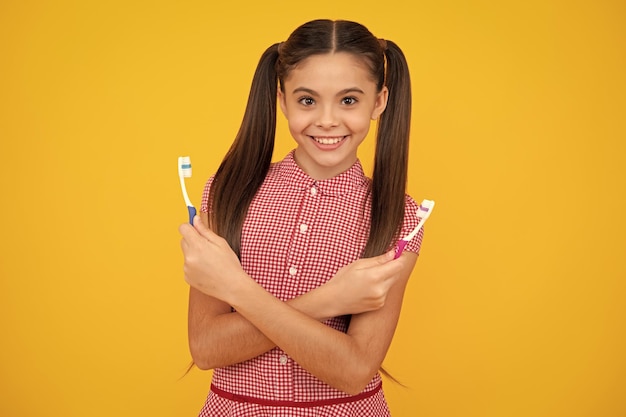 Oral hygiene dental Teenage girl brushing her teeth Teen holds a toothbrush in hand brushing her teeth morning routine dental hygiene teeth care Happy teenager positive and smiling emotions