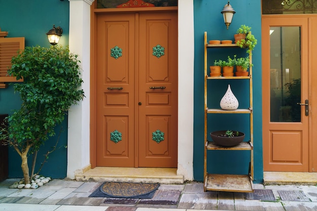 Orange ancient doors and blue walls Green plants on pots outdoors