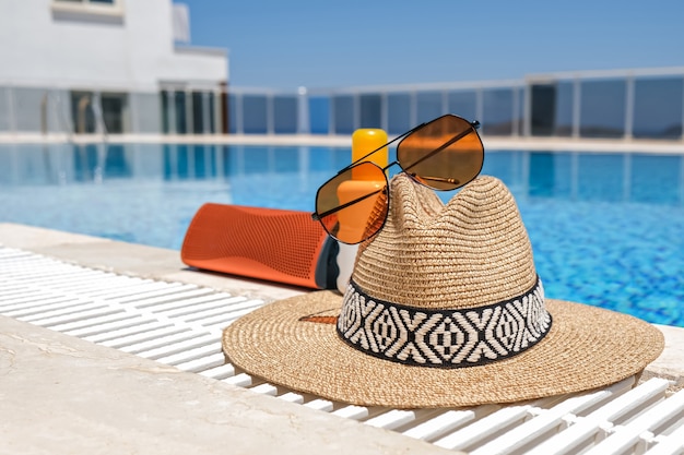 Orange beach accessories swimming pool. sunglasses, music speaker and straw hat.