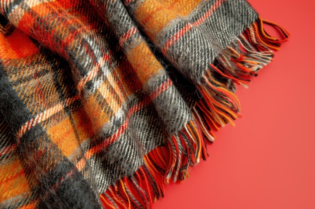 Orange and Black Plaid Blanket With Fringes on Red Background