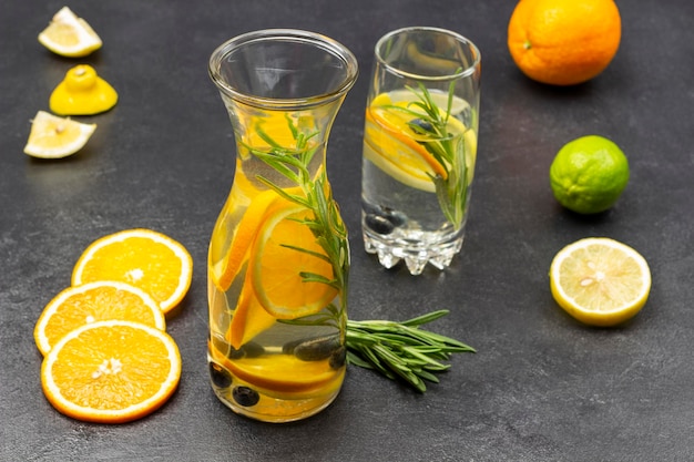 Orange blueberries and rosemary infused water in glass and bottle