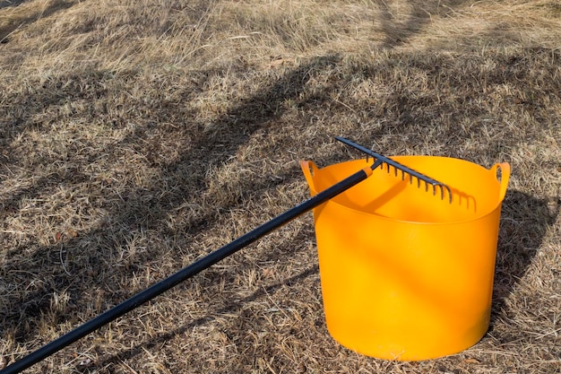 Photo orange bucket and black rake gardening equipment and tool