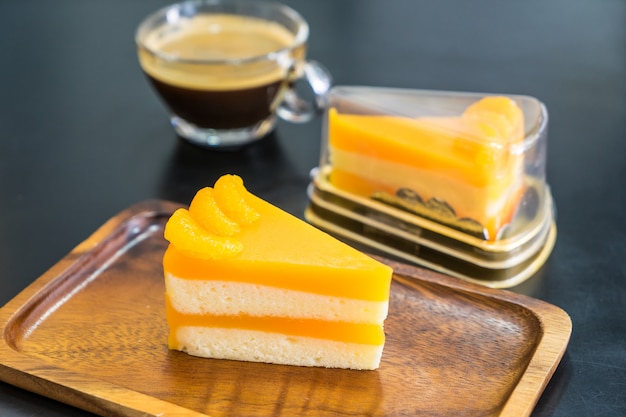 Orange cake with orange topping on the wooden dish