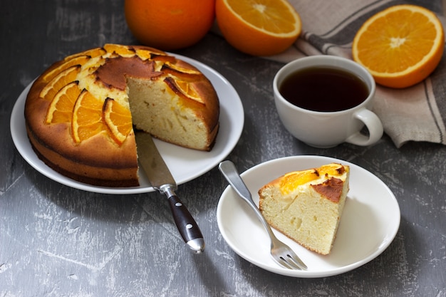 Orange cake with slices of orange on a concrete surface