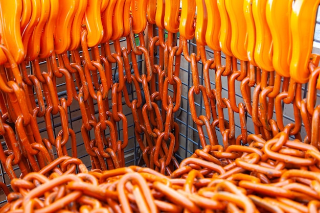 Orange chains with hooks for fastening heavy loads stacked in a steel basket