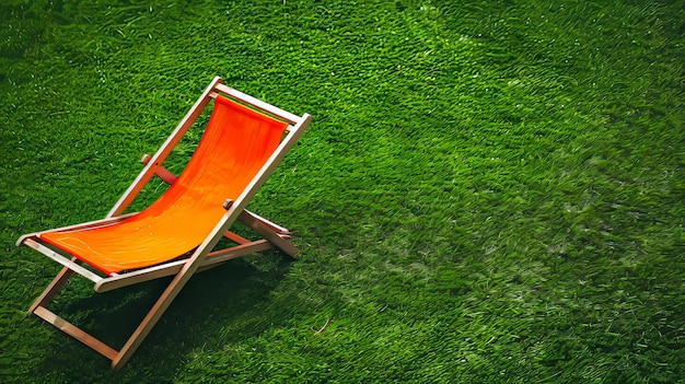 Photo an orange chair is sitting on a green lawn