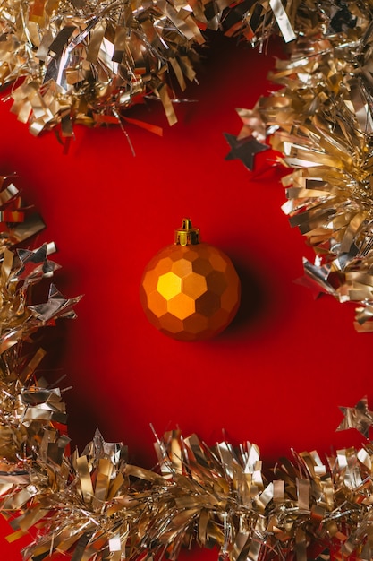 Orange Christmas ball toy on red background